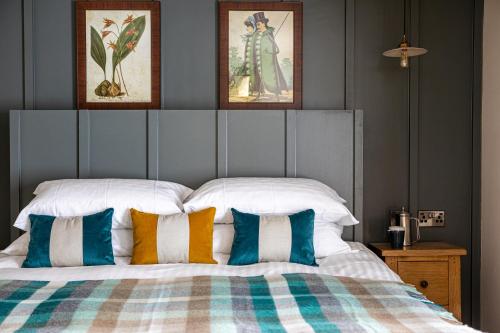 a bedroom with a large bed with colorful pillows at The Filly Inn in Brockenhurst