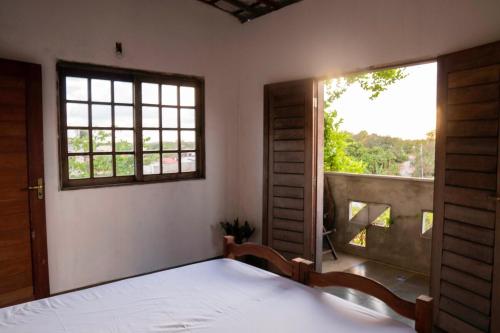 a bedroom with a bed and a large window at Casa Anéis de Saturno in Pipa