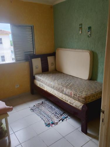 una camera da letto con un letto nell'angolo di una stanza di Apartamento Recanto dos pássaros a Peruíbe