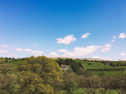 a view of a field with trees and a house at St Marks Stays in Sedbergh