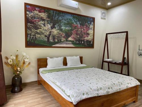 a bedroom with a bed with a painting on the wall at Trang An ViewPoint Homestay in Ninh Binh