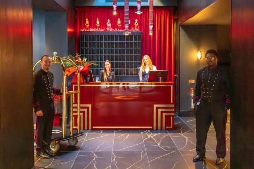 a group of people standing in front of a reception desk at Hotel Gotham Newcastle in Newcastle upon Tyne