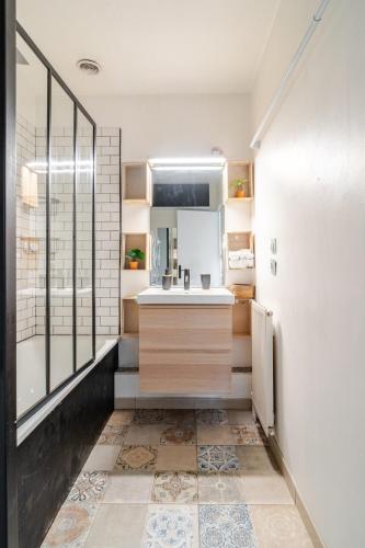 a bathroom with a sink and a mirror at Duplex Plaisir - 25 min du centre de Paris - avec Parking in Plaisir
