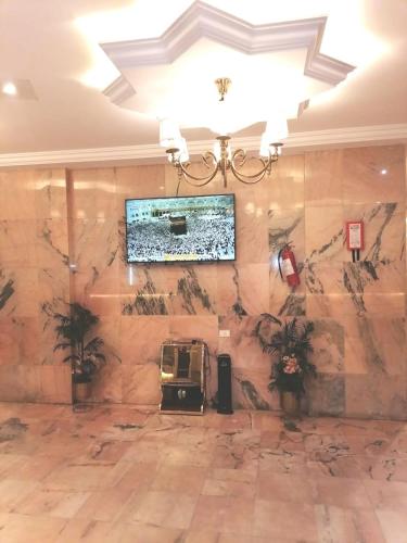 a large room with a stone wall and a chandelier at فخامة المصيف للشقق المخدومة 2 in Taif