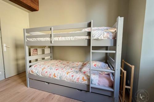 Un dormitorio con dos literas en una habitación. en L'Ecrin Balgentien - A deux pas de la Loire et du Centre, en Beaugency