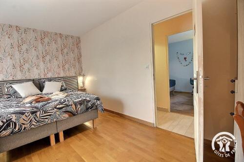 a bedroom with a bed and a door leading to a hallway at La croix au roi in Lamballe Armor