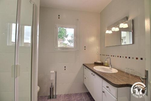 a white bathroom with a sink and a shower at La croix au roi in Lamballe Armor