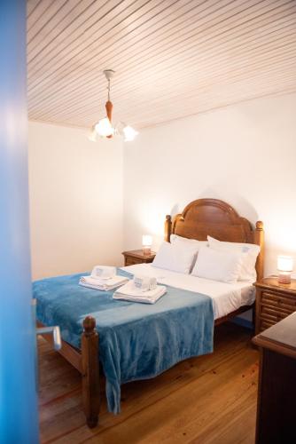 a bedroom with a bed with a blue blanket at Viana Fishers House - Pool & Beach ! in Viana do Castelo
