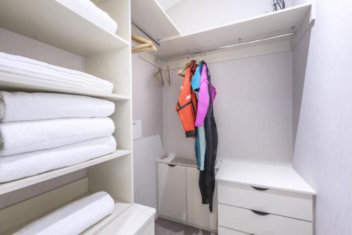 a walk in closet with towels and clothes at Lodge 15 at Landscove Holiday Park in Brixham