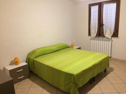 a bedroom with a bed with a green bedspread at Casa Madonie Isnello in Isnello