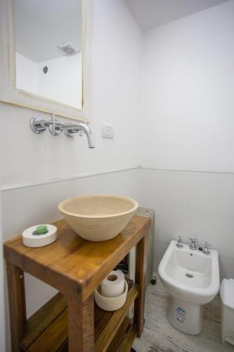 a bathroom with a bowl sink and a toilet at ASM Apart IX in Merlo