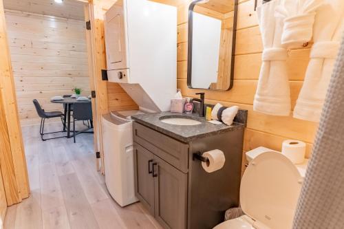 a bathroom with a sink and a toilet in a tiny house at Green & Black Bear Cabins By Beyond Expectations in Sevierville