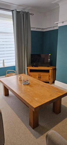 a wooden coffee table in a room with a television at Driftwood Cottage in Redcar