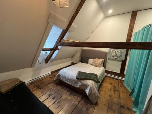 a bedroom with a bed in a attic at Om chalet 1 avec spa face au fleuve in Saint-Jean