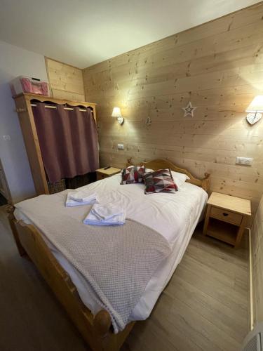 a bedroom with a bed in a wooden room at Chalet AIGUILLON RDC D in Le Lioran