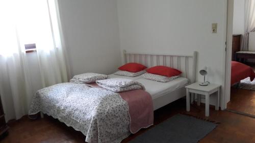 um quarto com 2 camas e almofadas vermelhas em Am Baalstein em Traunkirchen