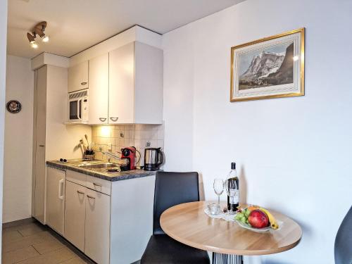a small kitchen with a table and a table and a table at Apartment Chalet am Reeti by Interhome in Grindelwald