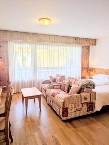 een slaapkamer met een groot bed en een tafel bij Centre Thermal NORD studio TH203 in Ovronnaz