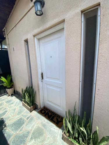 een witte garagedeur met planten voor een huis bij Casita en general Pacheco in General Pacheco