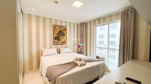 um quarto com uma cama com um ursinho de pelúcia em #2207A# Flat mobiliado no Jardim Goias em Goiânia