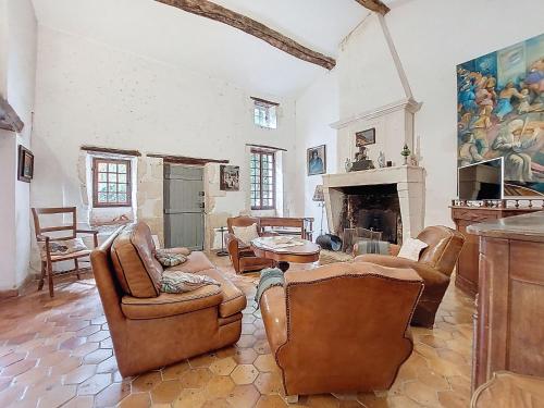 een woonkamer met leren stoelen en een open haard bij Holiday Home Petichaud by Interhome in Saint-Sulpice-dʼArnoult