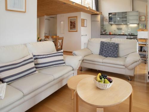 een woonkamer met witte meubels en een fruitschaal op tafel bij Apartment Schweizerheim Apt-5 by Interhome in Wengen