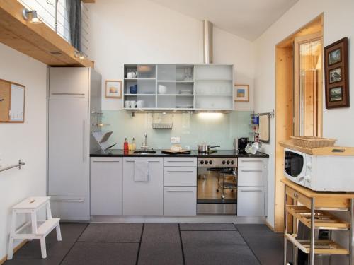 een keuken met witte kasten en een magnetron bij Apartment Schweizerheim Apt-5 by Interhome in Wengen