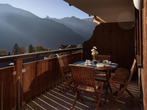 a table and chairs on a balcony with a view at Apartment Bella Vista Apt- No- 10 by Interhome in Wengen