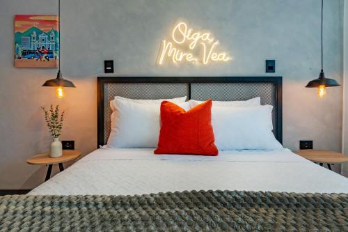 a bedroom with a bed with orange and white pillows at Sueño Caleño in Cali
