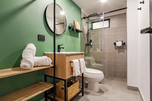 a bathroom with green walls and a toilet and a shower at Sueño Caleño in Cali