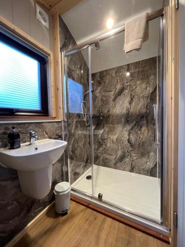 un bagno con doccia e lavandino di Inverpod a Lochinver