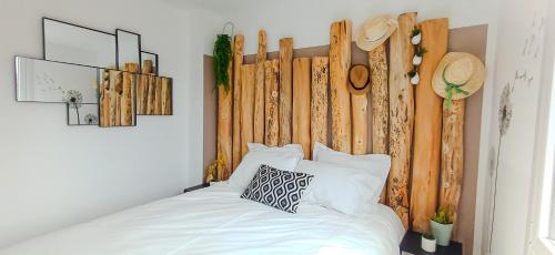 nid'Opale maison cosy à 3 minutes des plages في ويميريوكس: غرفة نوم مع سرير مع اللوح الأمامي الخشبي