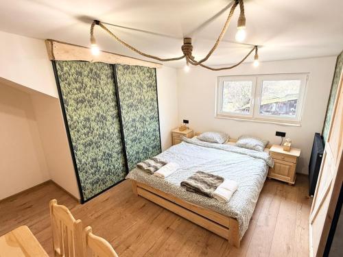 ein Schlafzimmer mit einem Bett und einem großen Fenster in der Unterkunft Dom Łowcy in Godzieszów