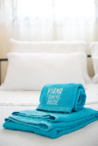 a pile of towels sitting on top of a bed at Viana Fishers House - Pool & Beach ! in Viana do Castelo