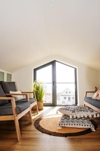 a living room with two chairs and a large window at Viana Fishers House - Pool & Beach ! in Viana do Castelo