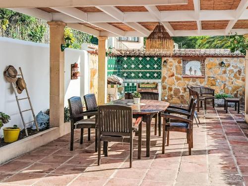 eine Terrasse mit einem Tisch, Stühlen und einem Kamin in der Unterkunft Holiday Home Isabelle by Interhome in Jávea