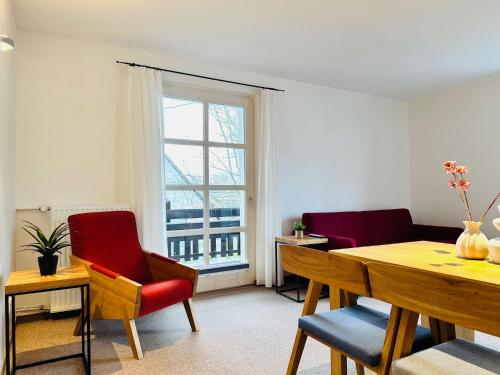 ein Wohnzimmer mit Tisch und Stühlen und einem Fenster in der Unterkunft Eichen Apartment- 4 Personen- Balkon- Parkplatz- Waschmaschine in Wolfsburg
