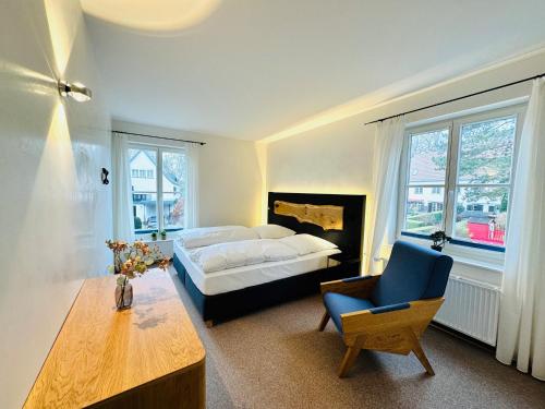 ein Schlafzimmer mit einem Bett, einem Stuhl und einem Tisch in der Unterkunft Eichen Apartment- 4 Personen- Balkon- Parkplatz- Waschmaschine in Wolfsburg