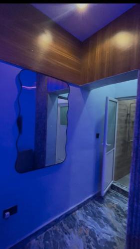 a room with a blue wall with a mirror at Blue AO service apartment in Lagos