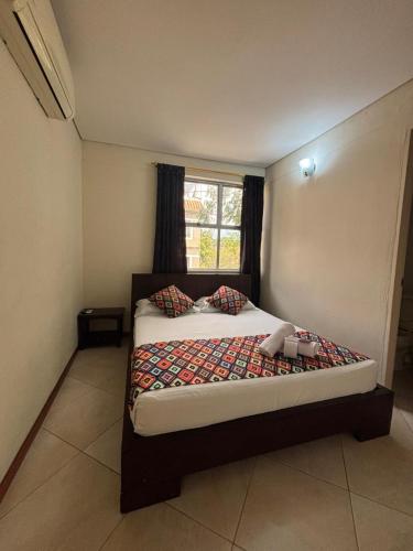 a bedroom with a large bed with a window at Hotel Tierra Santa Santa Fe de Antioquia in Santa Fe de Antioquia