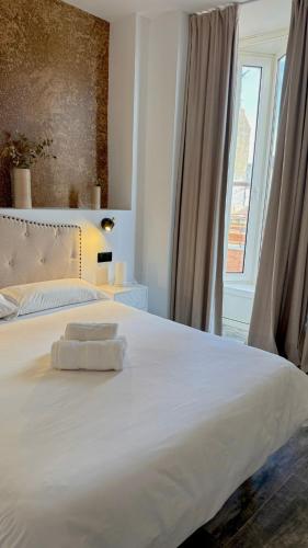 a bedroom with a large white bed with a window at William Martin Apartments in Huelva