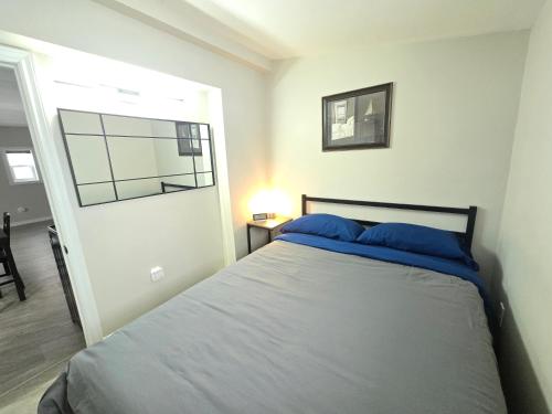 a bedroom with a bed with blue pillows on it at Cozy home on a quiet street minutes to DT Kingston in Kingston