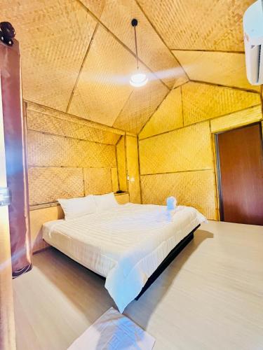 a bedroom with a bed in a wooden room at Lanta Thai Cottage, Bamboo House in Ko Lanta