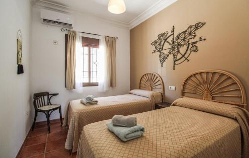 a room with three beds and a chair and a window at Villa el Cortijo in Torrox