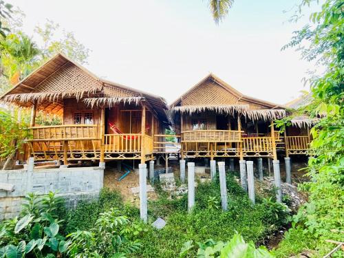 a group of houses with thatched roofs at Lanta Thai Cottage, Bamboo House in Ko Lanta