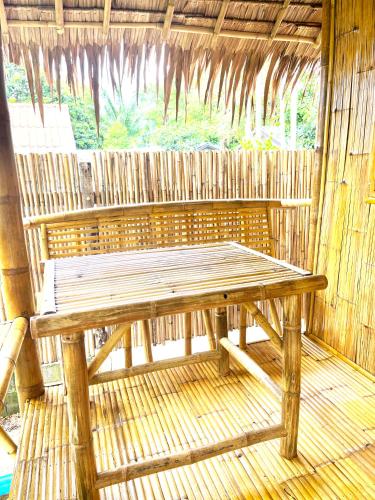 a wooden bench in a hut with a window at Lanta Thai Cottage, Bamboo House in Ko Lanta