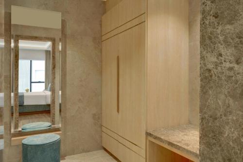 y baño con armario de madera y espejo. en The Fern Residency Bengaluru, Seshadripuram, Series by Marriott, en Bangalore