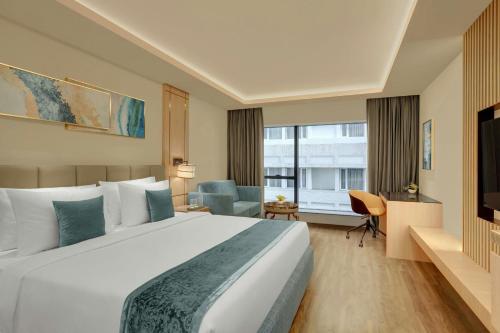 Una habitación de hotel con una cama grande y una ventana grande. en The Fern Residency Bengaluru, Seshadripuram, Series by Marriott, en Bangalore
