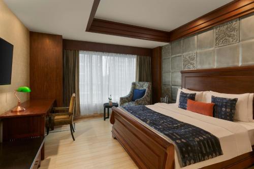a hotel room with a large bed and a desk at The Fern, Jaipur, Series by Marriott in Jaipur