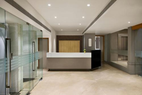 a lobby with a reception desk and a glass door at The Fern Residency Woodland, Pune, Series by Marriott in Pune